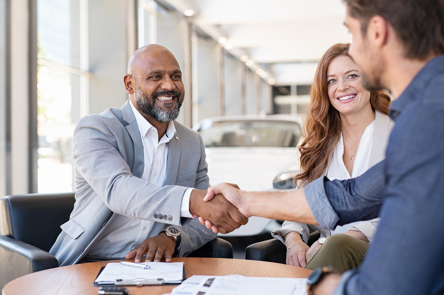 Man shaking hand of Volkswagen Team member after reviewing vehicle options